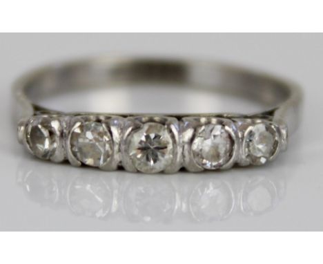 White metal five stone diamond ring, the round cut diamonds in rub-over settings, on plain  shank, no visible hallmark, size 