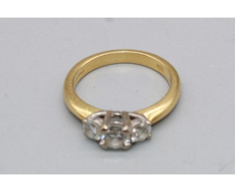 18ct yellow gold three stone diamond ring set with a large central diamond flanked by two smaller diamonds, stamped 750, size