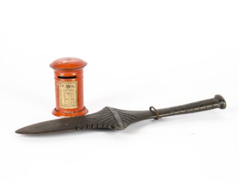 A Victorian tinplate money box in the form of a post box, height 10cm, together with a carved wooden tribal item, length 37cm