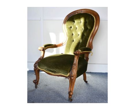 A Victorian walnut button back armchair, with scroll arms and legs, with brass castors and green velvet upholstery, width 66c