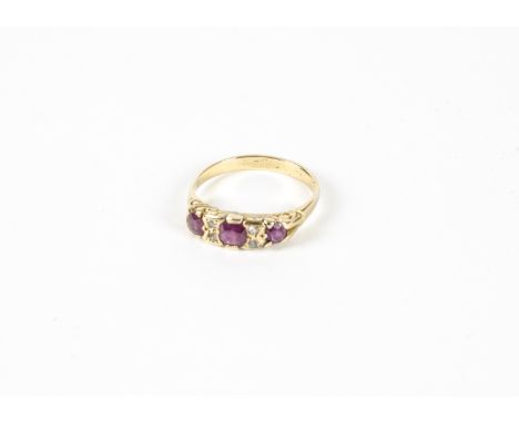 A Victorian ruby and diamond ring, three graduated round and oval cut rubies separated by a pair of accent diamonds in a carv