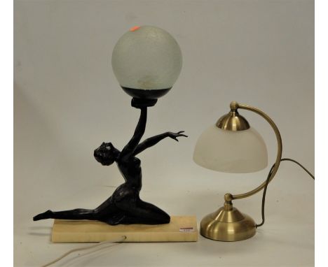 An Art Deco style table lamp the spelter female figure in dancing pose with one arm raised holding a globular shade on faux m