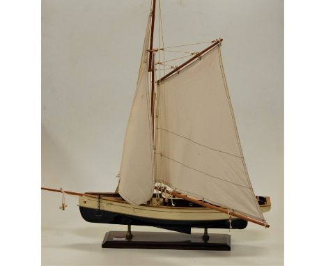 A painted wooden model of a yacht with full rigging on plinth base