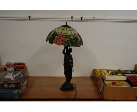 A modern table lamp in the Art Nouveau style having leaded glaze shade, supported by a resin figure of a robed maiden, height