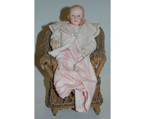 A Gebruder Heubach bisque head doll, having painted brown eyes and painted closed mouth, with bent limbed composition body, h