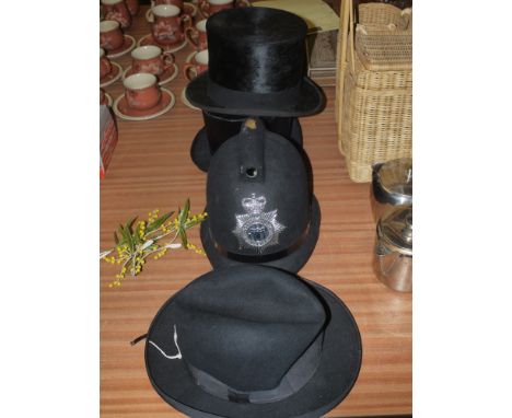 Two top hats; a policeman's helmet; and a Homburg hat.