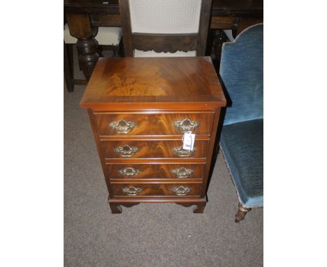 A miniature reproduction mahogany chest of four drawers with flame veneered fronts and ornate brass handles, raised on bracke