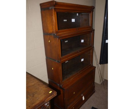 A mahogany globe wernike sectional bookcase of four graduating sections, three with glazed up-and-over panelled doors, the ot