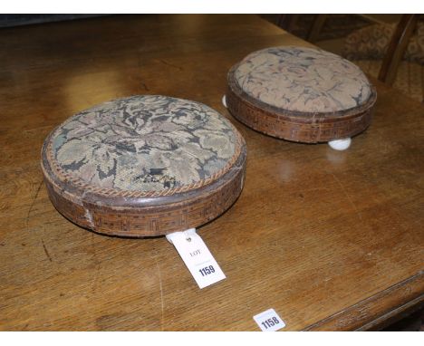A pair of 19th Century small circular footstools with inlaid mahogany frames, each raised on three ceramic bun feet.