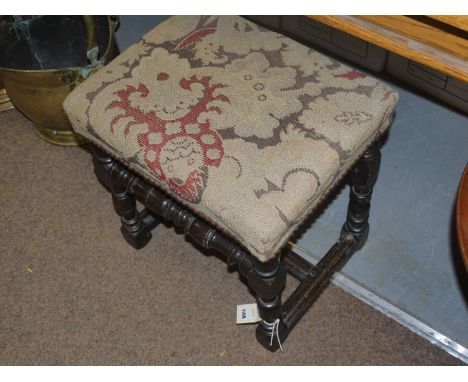 A stained wood rectangular stool with tapestry seat, raised on turned legs joined by stretchers.