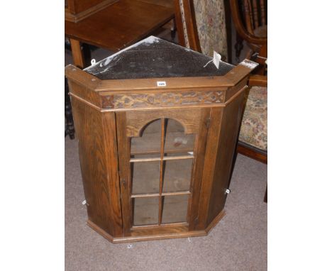 Early 20th Century oak wall hanging corner cabinet, with single glazed panel door enclosing shelves.