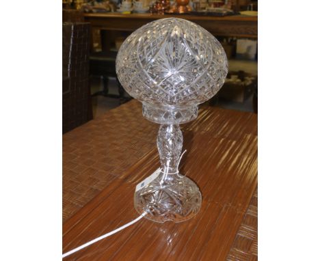 A large cut glass table lamp with globular shade and shaped base.