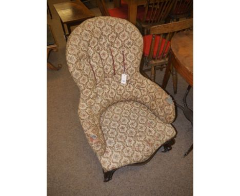 A lady's Victorian easy chair with fiddle shaped back and buttoned upholstery (distressed), raised on shaped front mahogany l