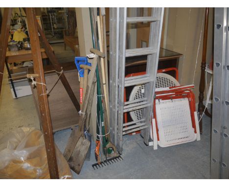 A folding garden table; and four matching chairs, in red and white; and a collection of garden tools.