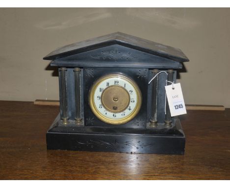 A Victorian mantel clock in black slate architectural style case with decorative reeded columns.