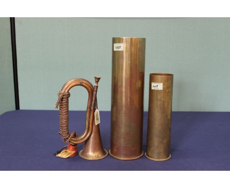 Two brass shell cases, one dated 1934 with a copper and brass bugle 