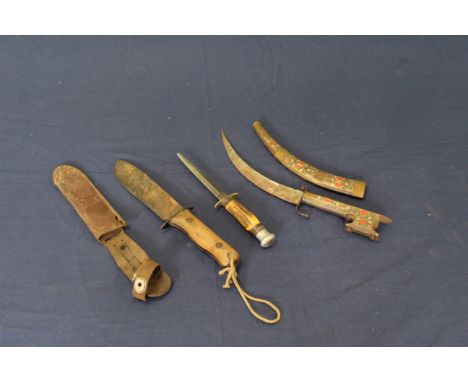 A Wilkinson issue marked survival knife (sheath as found) with a commando style sheath knife and an ethnic example