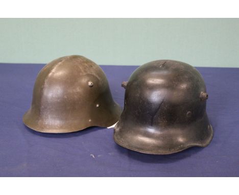 A German WWI era helmet, shell only (as found) with a Bulgarian helmet M36, WWII era