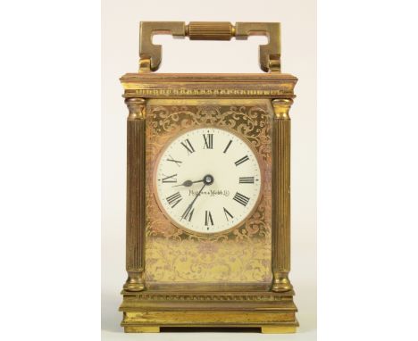 An early 20th century Mappin and Webb brass corniche cased carriage clock, the dial with Roman numerals and applied scroll de