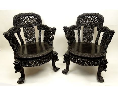 Pair 19/20th Century Deep Relief Carved Chinese Hardwood Chairs. Ornately Carved Dragon Motif with Paw Feet. Typical Joint Se