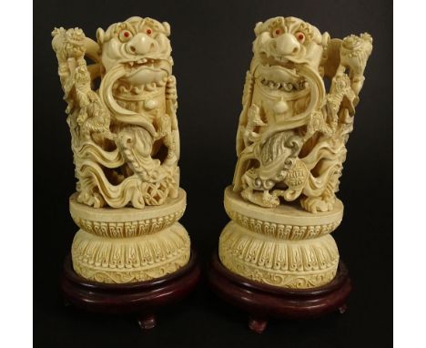Pair Chinese Carved Ivory Foo Dogs on Hardwood Stands. Inset Coral Eyes. Deep Relief Carving. Unsigned. Typical Light Age Cra