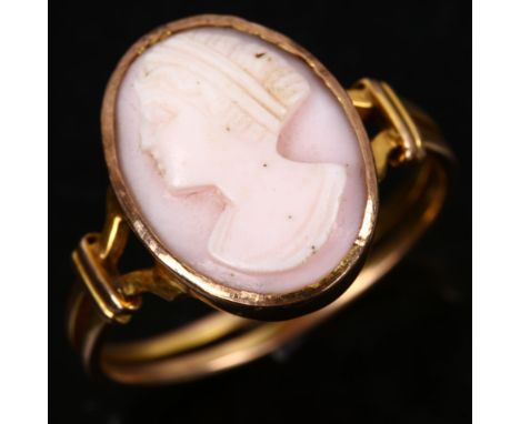 An unmarked gold relief carved pink coral cameo ring, depicting female profile, setting height 16mm, size Q, 2.8gNo obvious d