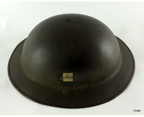 A WW2 British Army steel helmet complete with liner & chin strap with the remains of a Division badge to the side