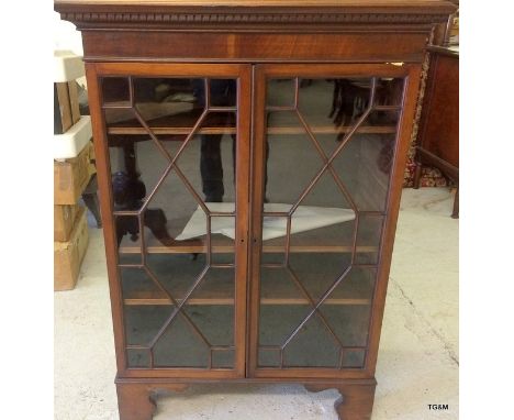 A mahogany glazed adjustable shelf bookcase with Chevron fit glass doors and shaped top 120 x 84 x 40cm