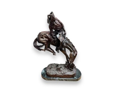 After Frederic Remington (American, 1861-1909), ‘Rattlesnake’, large bronze of a cowboy on horseback, on a green marble base.