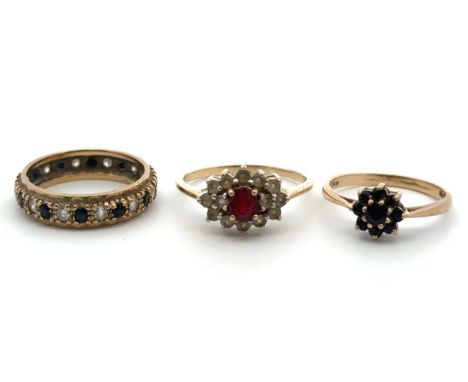 Thee 9ct gold and ruby/ sapphhire rings. A 9ct sapphire flower ring size N, a sapphire and CZ eternity ring, size P, and a ru