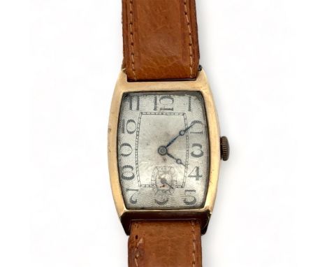 A 9ct gold 15 jewel wrist watch. Engine turned pattern dial, Arabic numerals, sub seconds dial and brown leather strap. Hallm