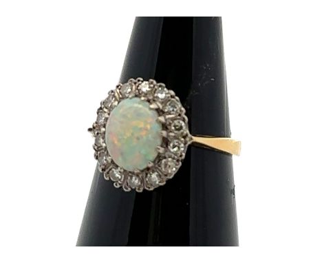 An 18ct yellow gold, opal and diamond ring. Opal (approx 9mm x 6mm) with full spectrum of colour surrounded by single cut dia