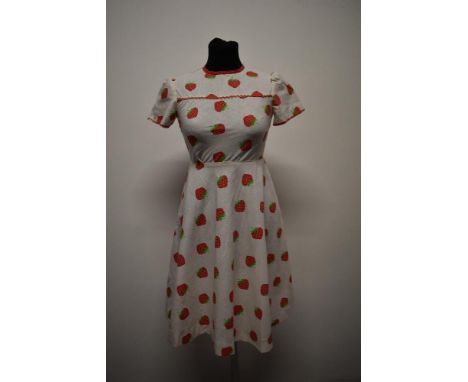 A 1950s/60s cotton dress, having strawberry print with red polka dot piping and Ric-Rac detail, back metal zip, small size.