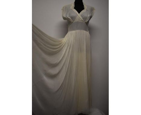 A cream tulle and taffeta evening dress, having lace collar with rhinestone accents, cross over bust with wide waistband and 