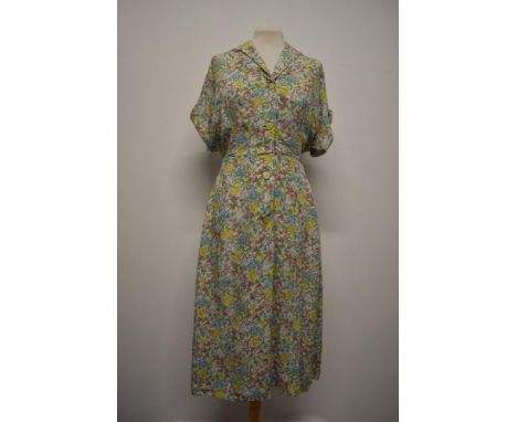 A 1940s cotton day dress, having novelty Lion and Unicorn print on floral ground, buttons to front and blouson bodice, larger