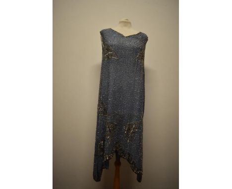 A pale blue 1920s flapper dress, having extensive gold and silver sequin detail throughout and scalloped hem which rises to t