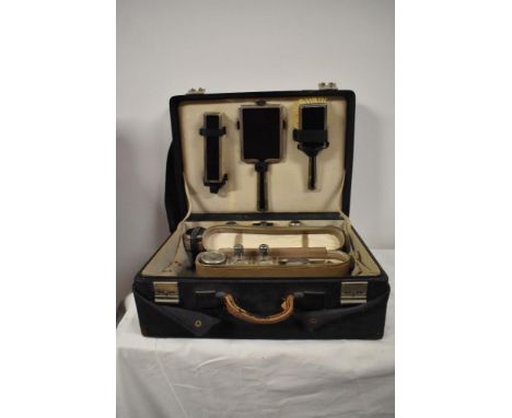 A 1930s/40s vanity travel case, housing a selection of jars and bottles, brushes and mirror etc.