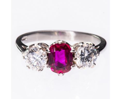 A BURMESE RUBY AND DIAMOND PLATINUM RING, the oval cut Burmese ruby set between two brilliant cut diamonds in pierced setting