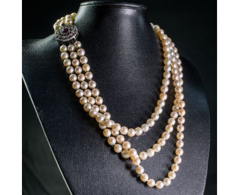 A CULTURED PEARL, RUBY AND DIAMOND NECKLACE, the three graduating strands of uniform cultured pearls each strung knotted onto
