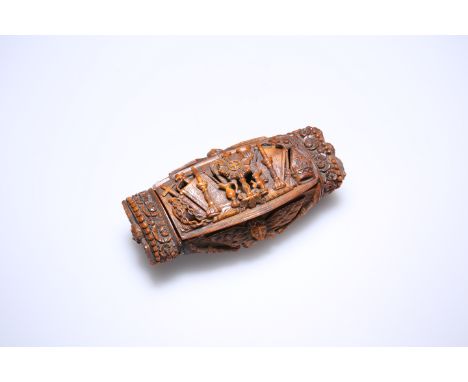 A 19th CENTURY CARVED COQUILLA NUT SNUFF BOX, the hinged cover carved in relief with religious artefacts including a monstran