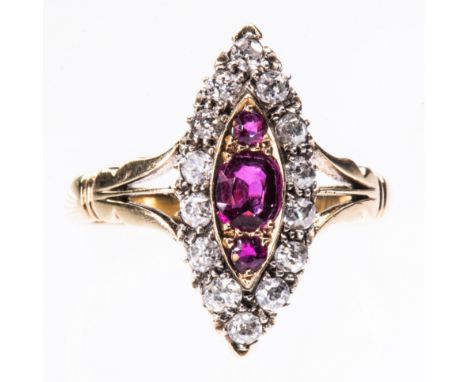 A LATE 19TH CENTURY RUBY AND DIAMOND RING, the marquise shaped mount set with three graduating ruby highlights within a surro