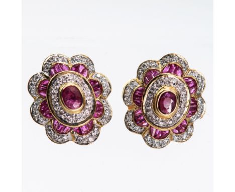 A PAIR OF RUBY AND DIAMOND CLUSTER EARRINGS, the central oval cut ruby highlight within a stepped scalloped edge surround of 