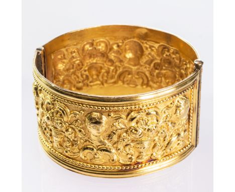 A RENAISSANCE STYLE BANGLE, the wide band with elaborately moulded Renaissance style decoration, on hinged fitting with pin c