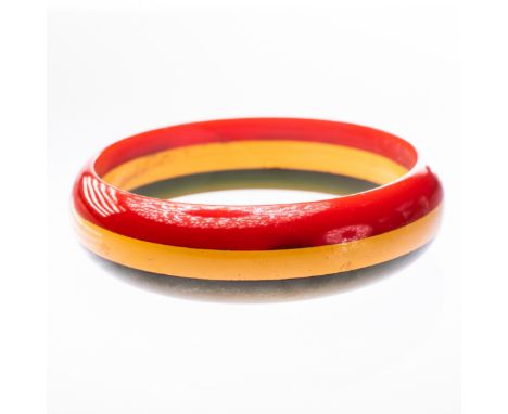 A 1950'S BAKELITE BANGLE, in green, yellow and red stripe design. Diameter 6.5cm. Weight 25.7gms.&nbsp;