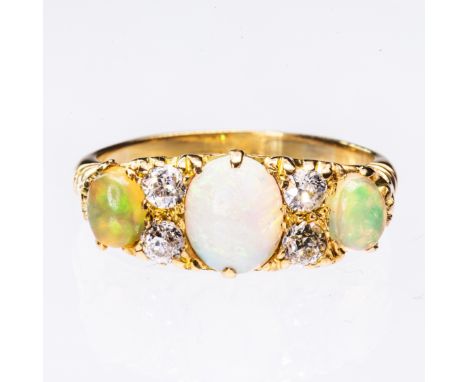 A LATE 19TH CENTURY OPAL AND DIAMOND RING, the three graduating oval cut opals and four brilliant cut diamond highlights all 