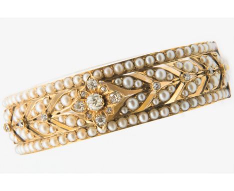 A VICTORIAN SEED PEARL AND DIAMOND BANGLE, the floral and foliage style mount set throughout with graduating seed pearl highl