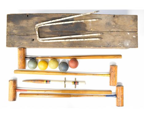 Vintage croquet set with four mallets, five iron hoops and five balls, in original wooden case.