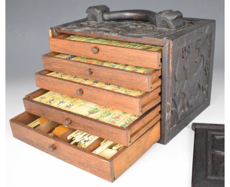 Chinese or similar Mahjong set with bone and bamboo tiles, in five drawer carved wooden cabinet with handle to top, width 24c