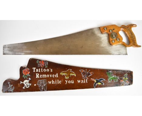 Novelty vintage woodworking saw with hand decorated cover 'Tattoos Removed while you wait', length 78cm