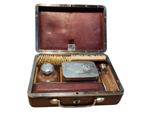 A late 19th century leather and silver plated vanity case, swan neck handle, the interior with brushes, scent bottles and box